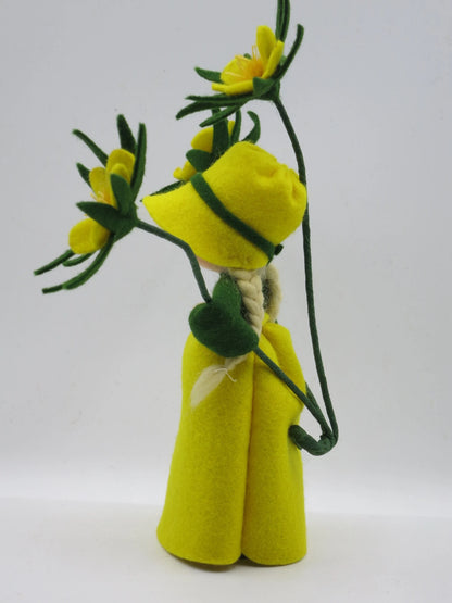 Winterling-Blumenkind seitlich mit grünem Kragen und gelben Filzblüten