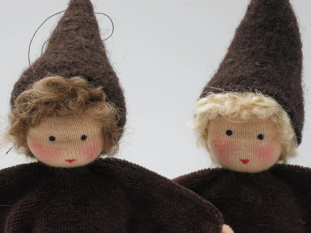 Nahaufnahme zweier Wurzelkinder Blumenkinder mit braunem und blondem Haar, Waldorf Jahreszeitentisch