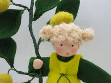 Zitronen-Blumenkind aus Wollfilz von oben gesehen, gelbes Trägerkleid und blondes Lockenhaar, Waldorf Jahreszeitentisch.