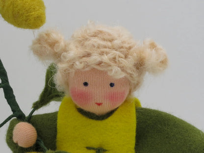 Gesichtsdetail des Zitronen-Blumenkinds mit gestickten blauen Augen, rosa Wangen und blondem Lockenhaar.