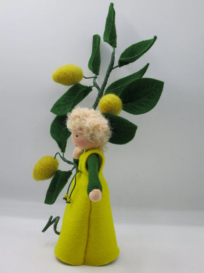 Seitenansicht des Zitronen-Blumenkinds aus Wollfilz mit Zitronenzweig und grüner Kordel am Trägerkleid.